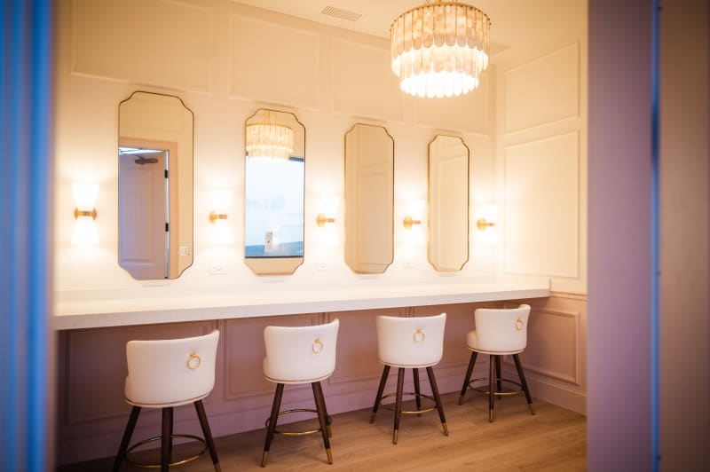 Getting-ready suite at The Chapel at Wimberley with a vanity, mirrors, sconces, and a chandelier